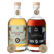 Two bottles of aged aguardente anise and grappa d'uva with labels and San Francisco World Spirits Competition gold medals on a white background