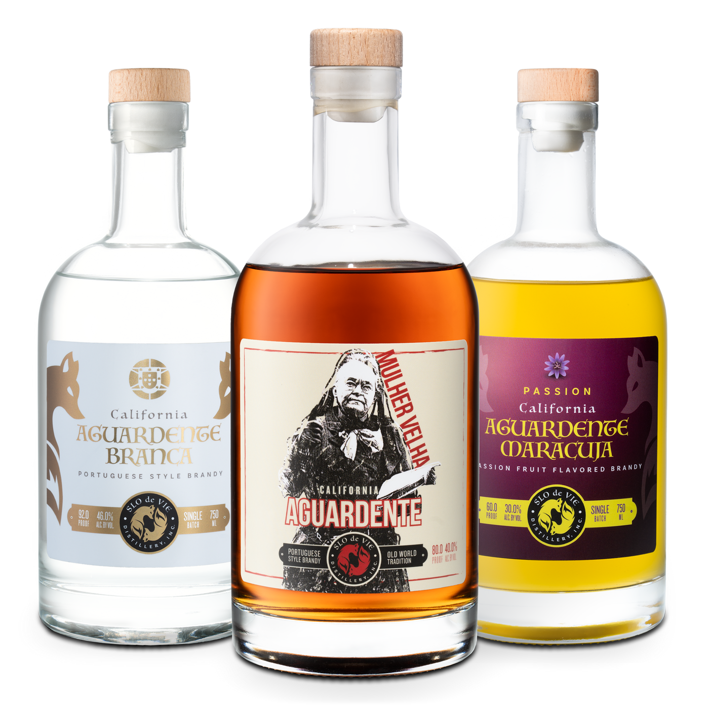 Three different style bottles of SLO de Vie aguardente on a white background